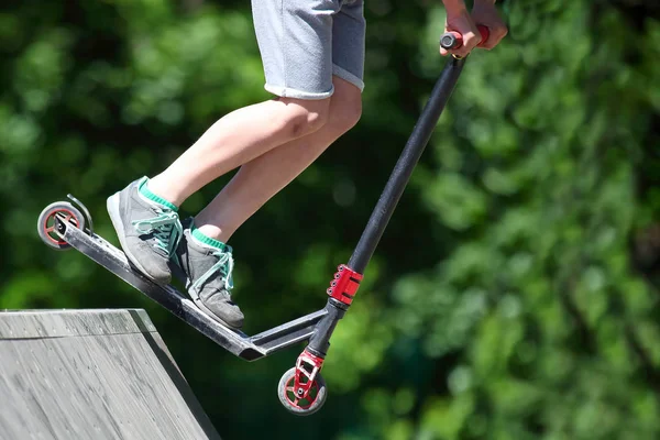 Adolescente pula em uma colina especial na scooter — Fotografia de Stock
