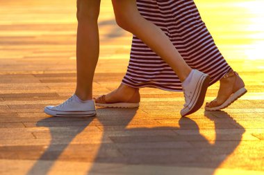 bacaklar güneş ışığı arka plan üzerinde yürüyen iki kişi