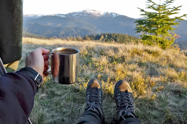 tourist with a cup of coffee in tent with mountain view