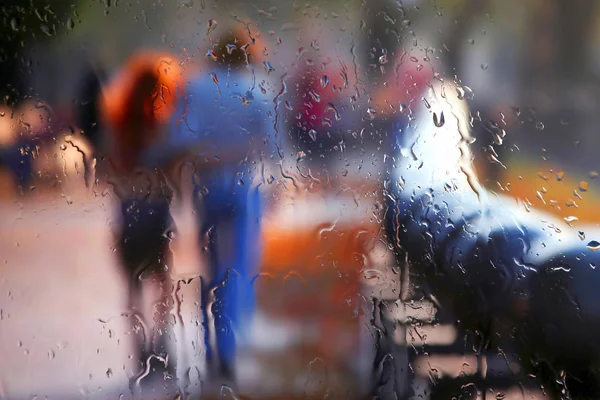 Silhueta vaga de duas pessoas através de vidro chuvoso — Fotografia de Stock