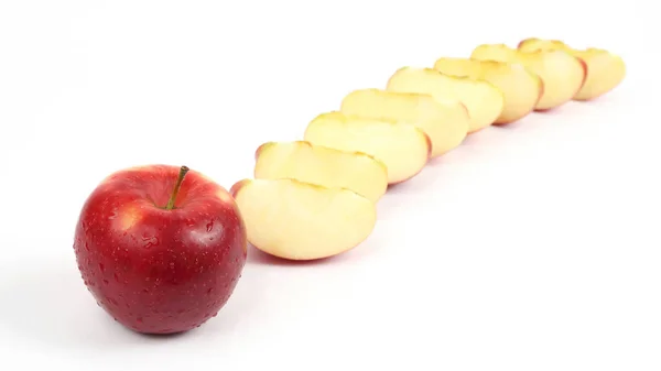 Mela rossa su uno sfondo di pezzi di mela tagliati — Foto Stock