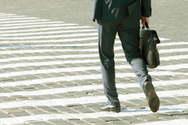 business man walks on a pedestrian crossing