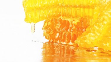 hafif bir arka plan üzerinde peteğin üzerinden akan bal