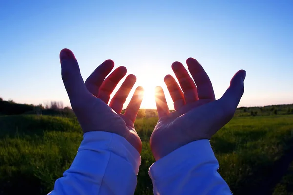 Felemelte a háttérben a naplemente kezek — Stock Fotó
