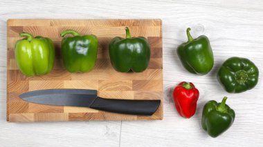 bir ahşap tahta üzerinde seramik bıçak ile tatlı biber