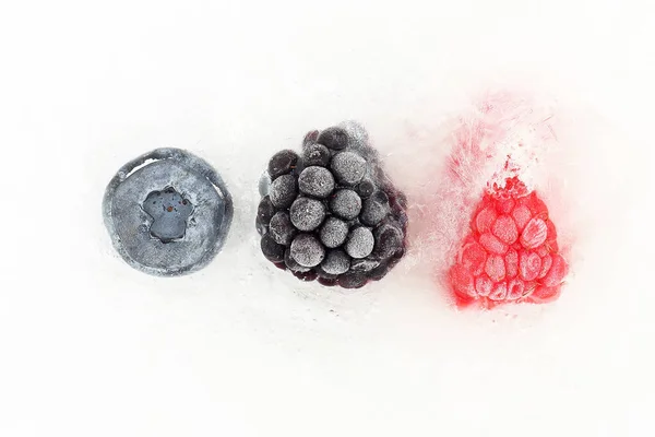 Arándanos, moras y frambuesas congelados en hielo — Foto de Stock