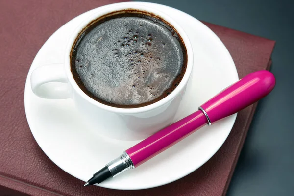 La penna rossa è una tazza di piattino di caffè nero — Foto Stock