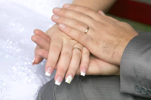 Noiva e noivo mostrar suas mãos usando anéis de casamento — Fotografia de Stock