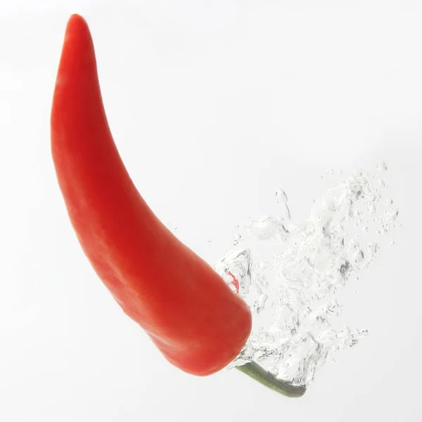 Peperoncino rosso che cade in acqua. verdure fresche sane e — Foto Stock