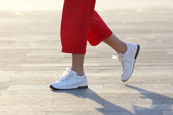 Piernas mujer caminando en la plaza de la ciudad — Foto de Stock