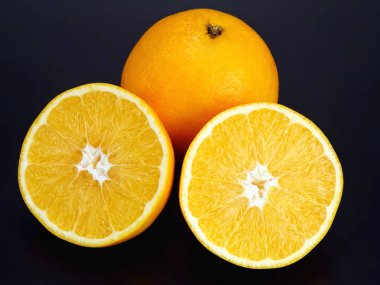 Citrus meyvesi. Kesim ve koyu arkaplanda turuncu