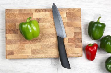 bir ahşap tahta üzerinde seramik bıçak ile tatlı biber