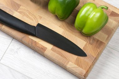 bir ahşap tahta üzerinde seramik bıçak ile tatlı biber