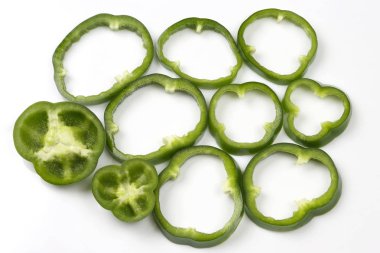 Beyaz arka plan üzerinde adet yeşil biber kesmek