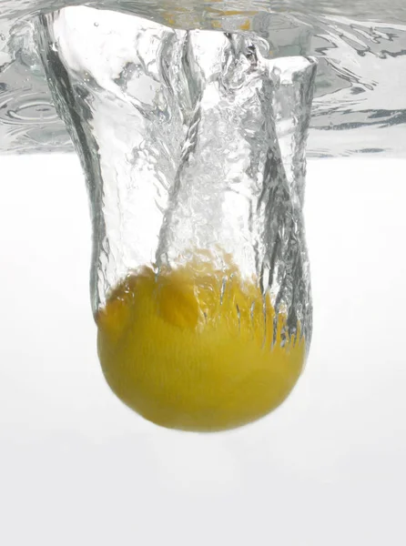 Cytryna wpada do wody. Przydatne witaminy żywności ow — Zdjęcie stockowe