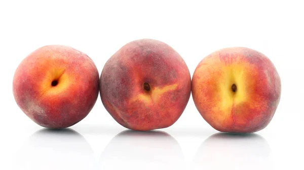 Три спелых персика на белом фоне — стоковое фото