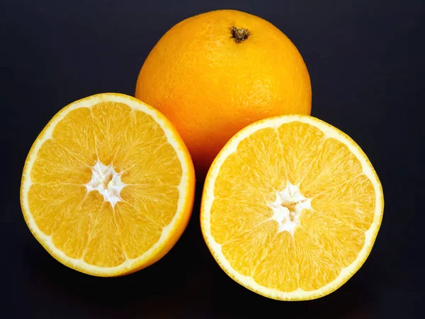 Owoce cytrusowe. Cięcie i cała pomarańcza na ciemnym tle — Zdjęcie stockowe