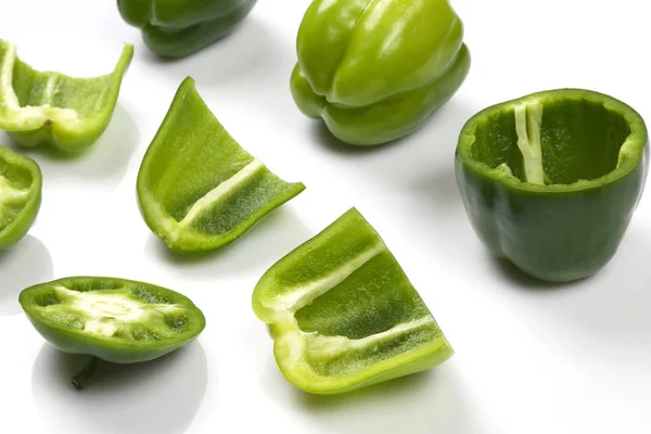 cut into pieces green peppers on white background