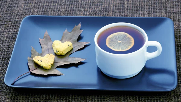 Vit kopp te med citron på ett tefat med cookies — Stockfoto