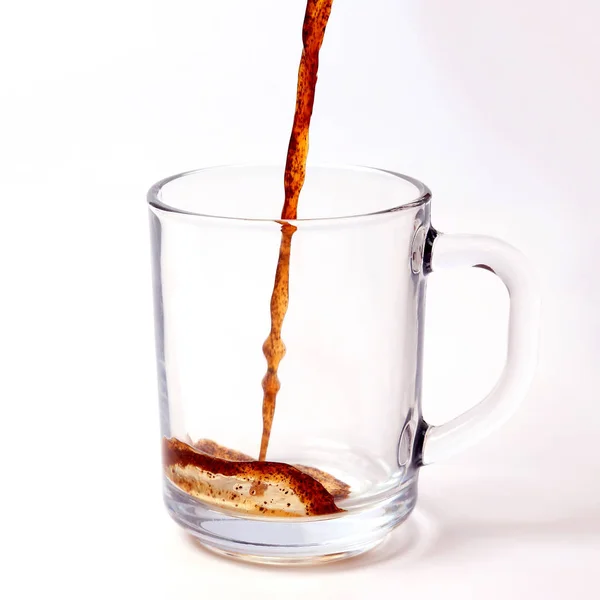 Black coffee is poured in a transparent mug on a white backgroun — Stock Photo, Image