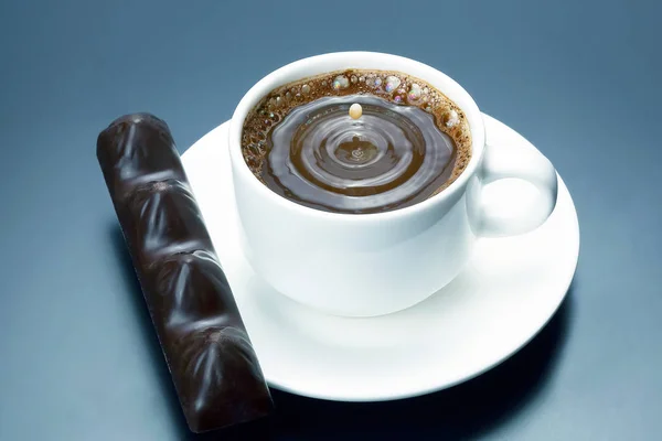 Gota de leche que cae en una taza blanca con café negro — Foto de Stock