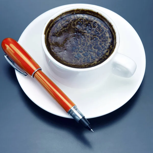 Caffè nero in tazza bianca e una penna rossa sulla salsa — Foto Stock