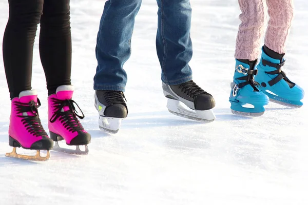 Voeten van verschillende mensen schaatsen op de ijsbaan. sport, Hobbie — Stockfoto