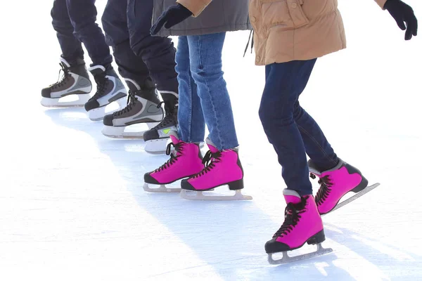 Voeten van verschillende mensen die schaatsen op de ijsbaan — Stockfoto