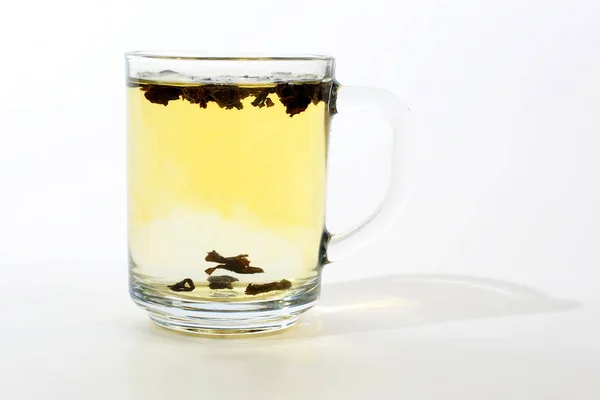 Transparent cup of tea with custard on white background — Stock Photo, Image