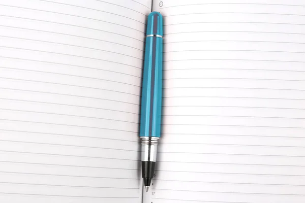 Penna liggande på en öppen Anteckningsboksf — Stockfoto