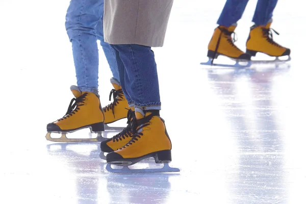 Pés de pessoas diferentes patinando na pista de gelo — Fotografia de Stock