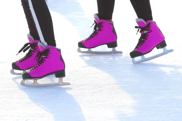 Pés em patins rosa em uma pista de gelo. esportes, Passatempos e recreação — Fotografia de Stock