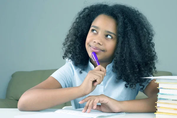 Svart Skolflicka funderar på skolan läxor gör homewor — Stockfoto