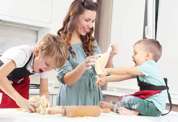the children help a young mother to knead the doug