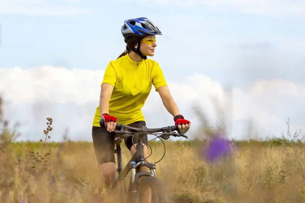 Schönes Mädchen in Gelb, das in der Natur Fahrrad fährt. Sport und rec — Stockfoto