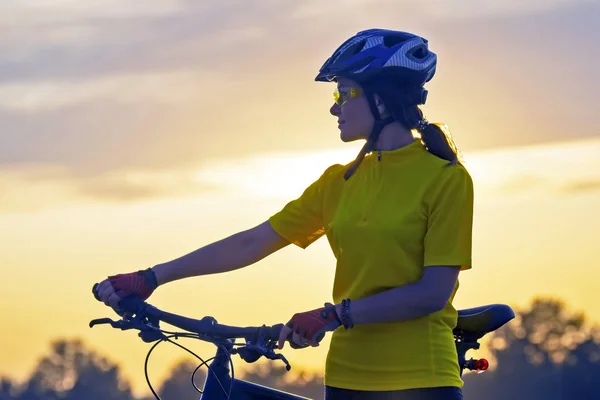 Porträt eines schönen Radfahrermädchens mit einem Fahrrad in der Hand — Stockfoto