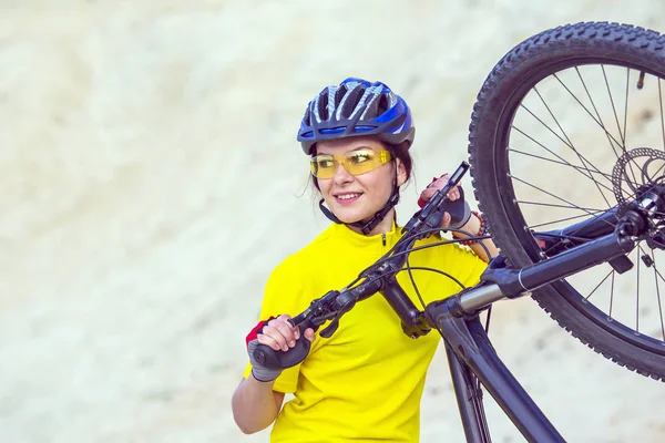 Beautiful girl cyclist with bike against the background of the S — Stock Photo, Image