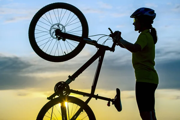 Silhouet van een meisje en een fietser met een fiets — Stockfoto