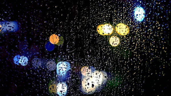 Отражение ночного света на влажном стекле — стоковое фото