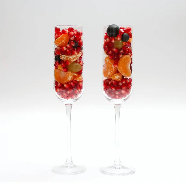 Дві склянки, наповнені фруктами на світлому фоні — стокове фото