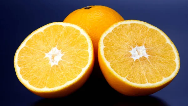 Cítricos. Corte y naranja entera sobre fondo oscuro — Foto de Stock