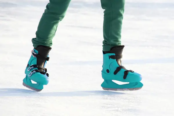 Piernas en patinaje azul en la pista de hielo. Deportes y vacaciones de invierno —  Fotos de Stock