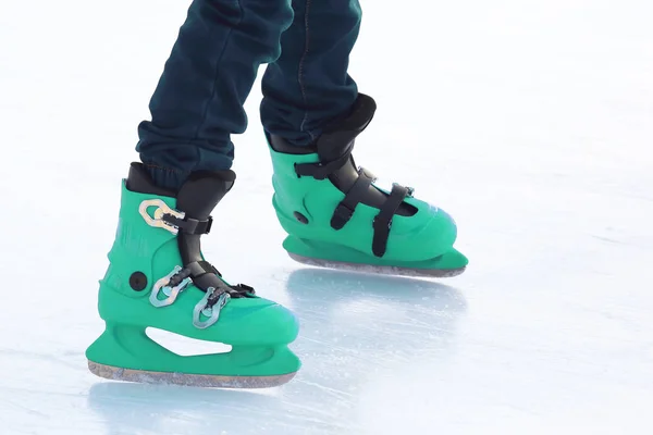 Piernas en patinaje azul en la pista de hielo. Deportes y vacaciones de invierno —  Fotos de Stock