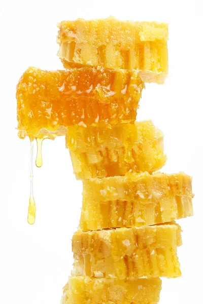 Honey flowing from the honeycombs on a light background — Stock Photo, Image