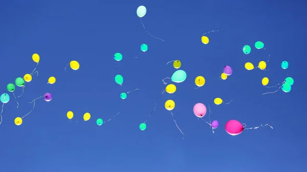 Molti palloncini multicolori che volano nel cielo blu — Foto Stock