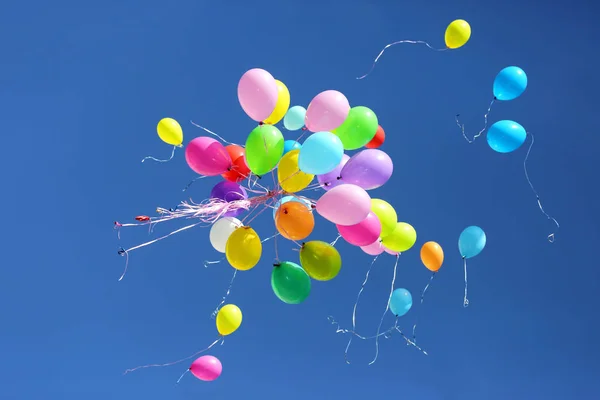 Grande número de balões coloridos contra o céu azul — Fotografia de Stock