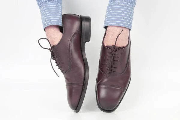 Classic brown shoes worn on the hands on a white background