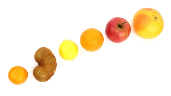 Различные фрукты на наклонной поверхности на белом фоне — стоковое фото