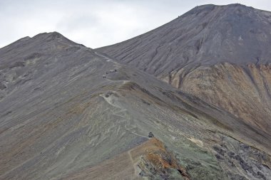 İnsanlar Landmannalaugar'daki volkana tırmanıyor. Icelan
