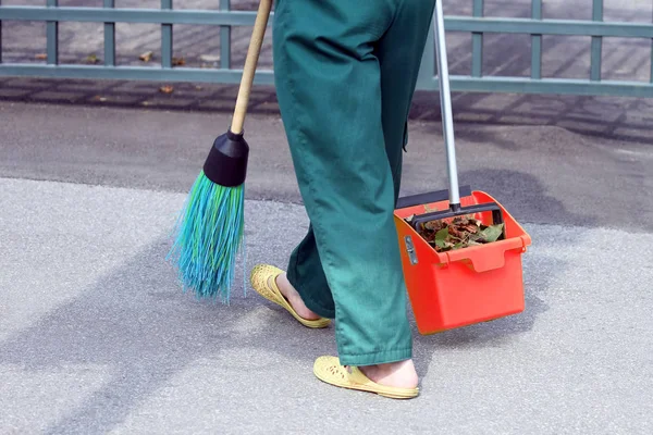 The janitor swept the city sidewalk from the fallen leaves — Stock Photo, Image